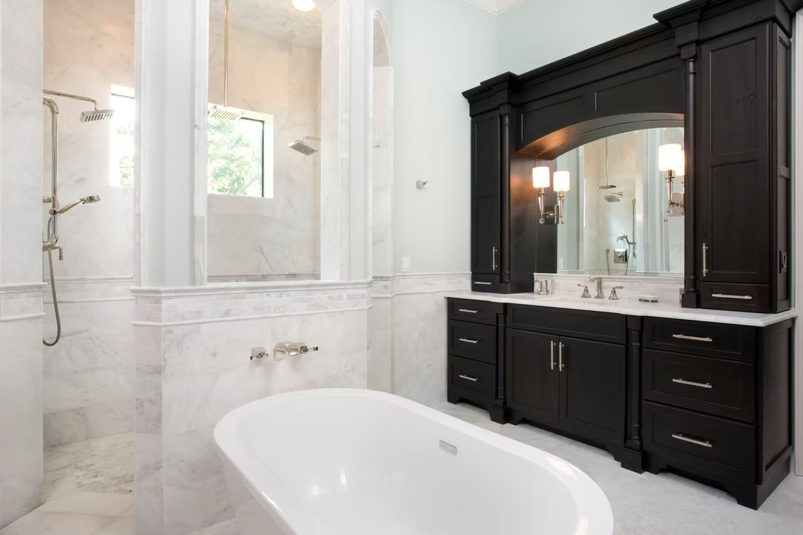 Luxury master bathroom featuring a spacious walk-in shower with frameless glass, marble-tiled walls, and a built-in stone bench.