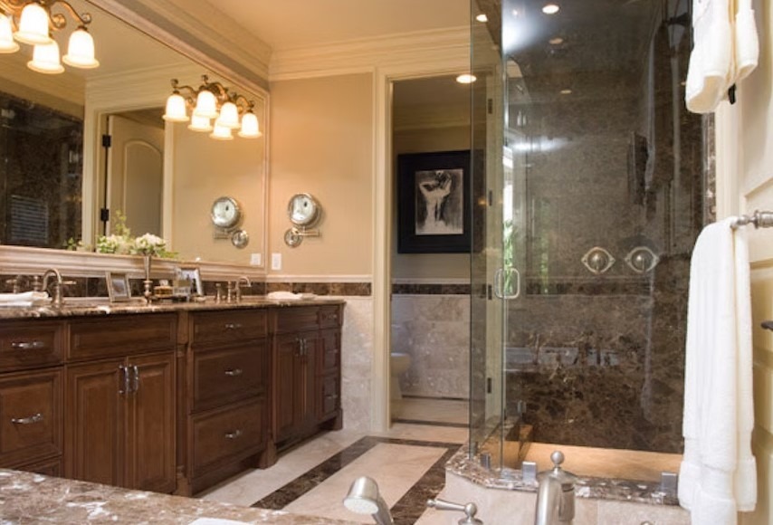 Luxury master bathroom featuring a spacious walk-in shower with frameless glass, marble tile walls, and a built-in stone bench.