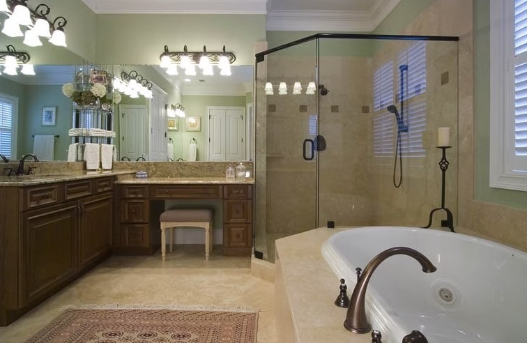 Luxury master bathroom featuring a freestanding white soaking tub, marble-tiled walls, and a large walk-in glass shower.