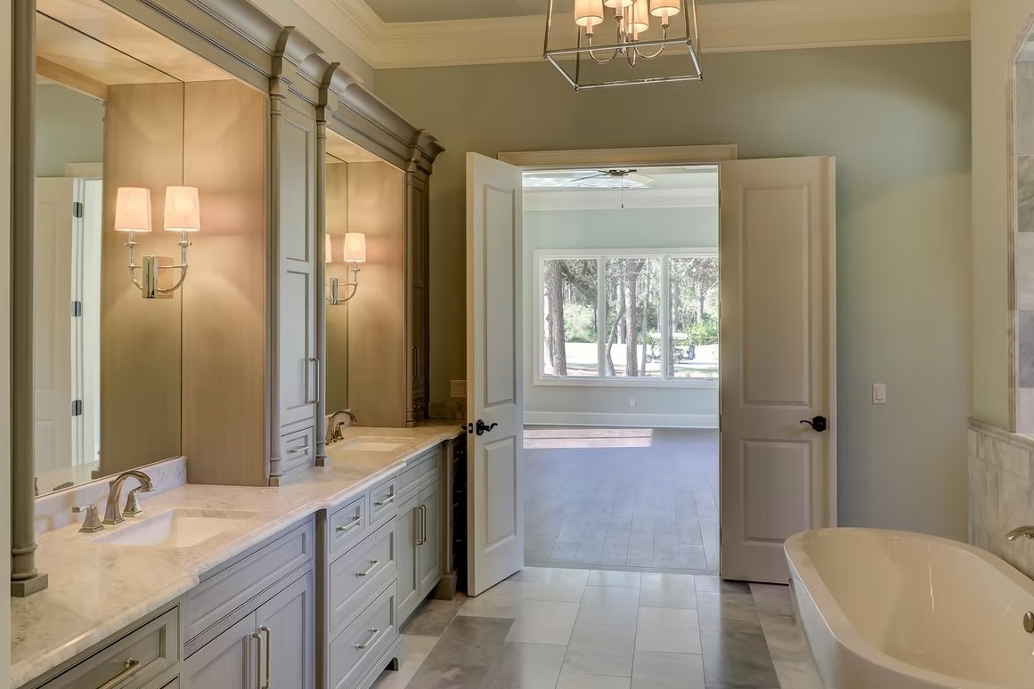 Luxury master bathroom featuring a spacious walk-in shower with frameless glass, marble tile walls, and a built-in stone bench.