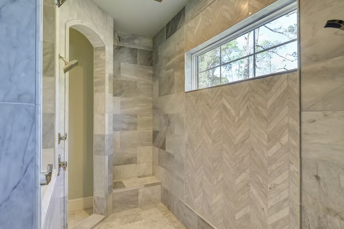 Elegant bathroom vanity featuring dual sinks, white shaker-style cabinetry, and a thick marble countertop with grey veining.