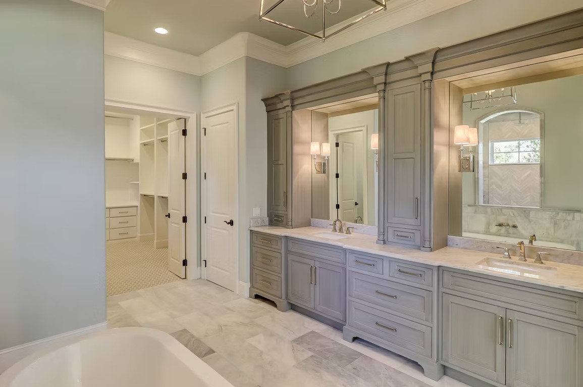 Luxury master bathroom featuring a spacious walk-in shower with frameless glass, marble tile walls, and a built-in stone bench.