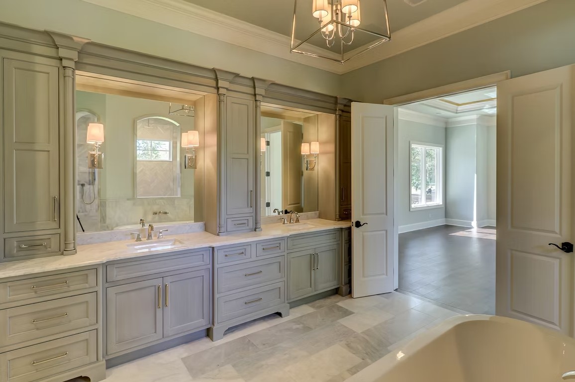 High-end bathroom featuring a seamless glass-enclosed shower, polished marble walls, and contemporary chrome fixtures.