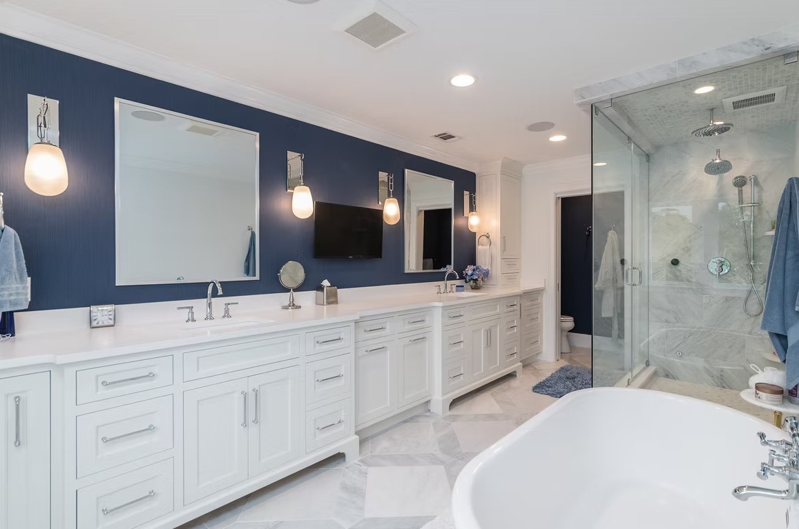 Luxury master bathroom with a walk-in glass shower, marble-tiled walls, and a built-in stone bench.
