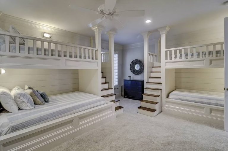 Custom built-in bunk room with four bunks, shiplap, and twin staircases