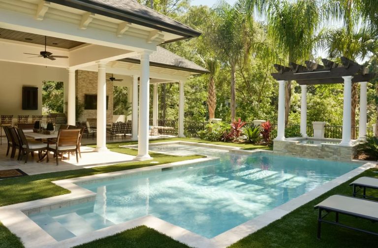 Covered patio with pergola, outdoor dining area, and pool at a luxury custom home