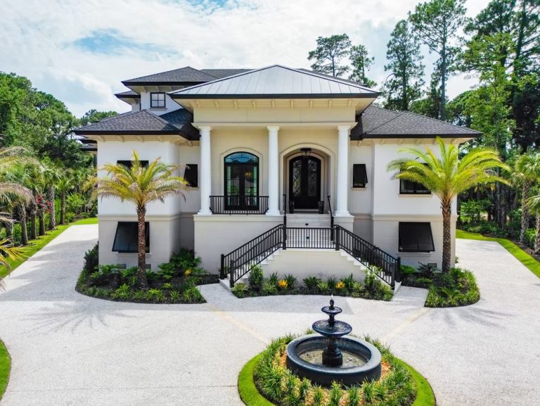 Mediterranean-style home with columned balcony, fountain, and circular driveway